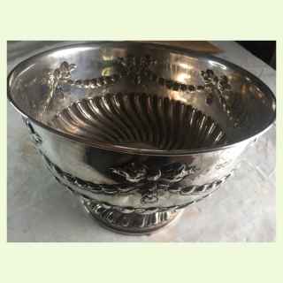 An silver rose bowl on a pedestal foot embossed with foliate scroll work,